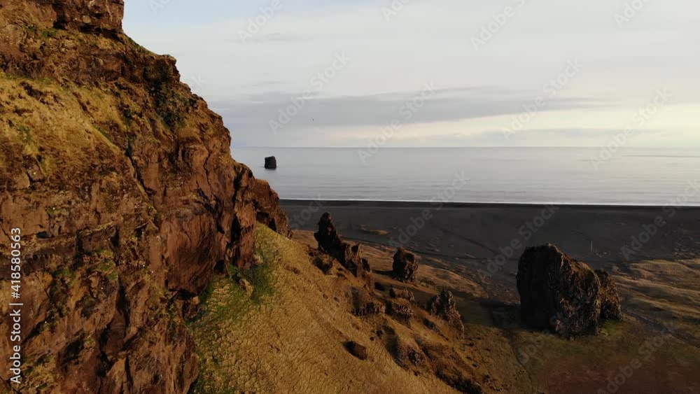 Dyrhólaey / Dyrholaey view point and its surrounding from an aerial drone 4k point of view, around the endless black sand beach during sunset, part2 