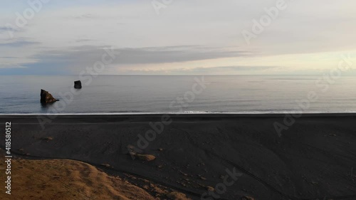 Dyrhólaey / Dyrholaey view point and its surrounding from an aerial drone 4k point of view, around the endless black sand beach during sunset, part3 