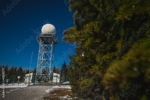 Doppler rain or weather radar on the top of the hill called Pasja Ravan in Slovenia on cold winter day. Beautiful sunny day and rain radar in between.