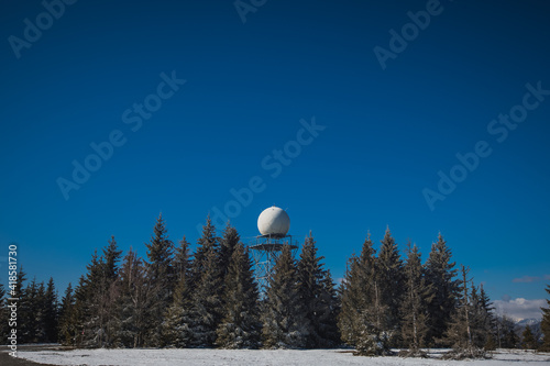 Doppler rain or weather radar on the top of the hill called Pasja Ravan in Slovenia on cold winter day. Beautiful sunny day and rain radar in between.