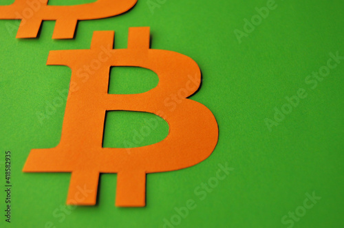 The sign of bitcoin is orange on a green background in the style of minimalism. Collage concept cryptocurrency. High quality photo