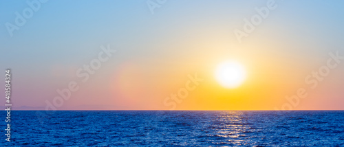 Orange sunset over sea. Bright sun over the sea horizon. Concept: vacation, relax, romantic