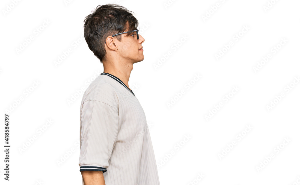 Young hispanic man wearing casual clothes and glasses looking to side, relax profile pose with natural face with confident smile. Young hispanic man wearing casual clothes and glasses looking to side, relax profile pose with natural face with confident smile.