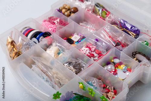 Close up shot of beads organizer or container for buttons  sewing and embroidery. Multicolored set of materials for handcraft  making of bijouterie and accessories.
