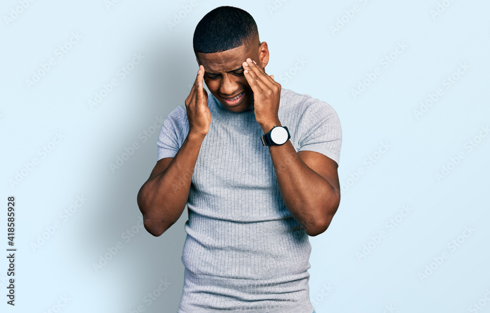 Young black man wearing casual t shirt with hand on head, headache because stress. suffering migraine. Young black man wearing casual t shirt with hand on head, headache because stress. suffering migraine.