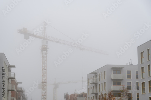 Construction cranes during the heavy mist.