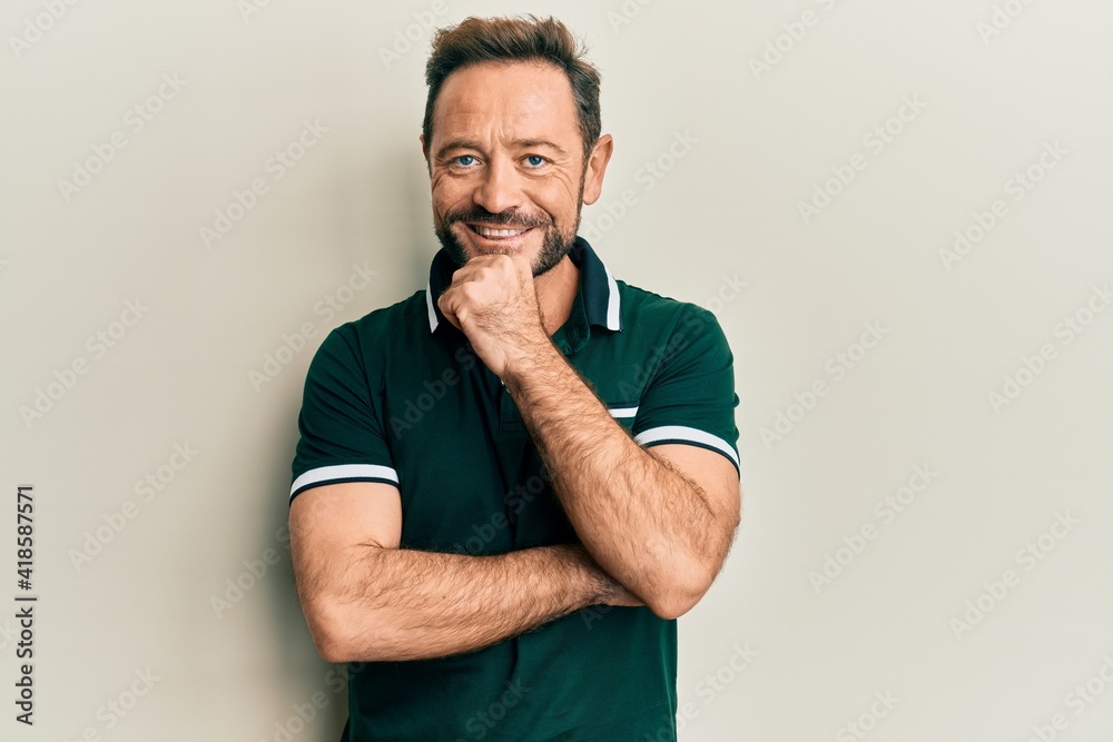 Middle age man wearing casual clothes smiling looking confident at the camera with crossed arms and hand on chin. thinking positive. Middle age man wearing casual clothes smiling looking confident at the camera with crossed arms and hand on chin. thinking positive.