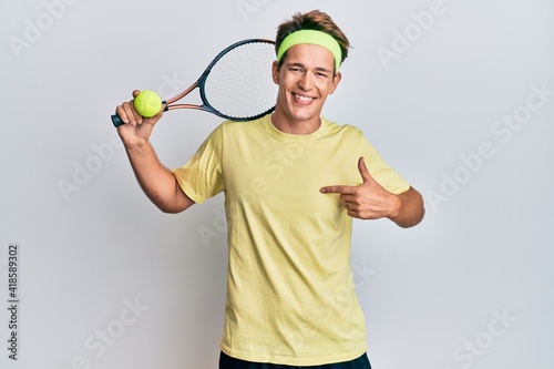 Handsome caucasian man playing tennis holding racket and ball pointing finger to one self smiling happy and proud © Krakenimages.com