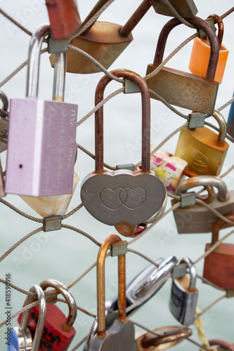 Love padlocks with heart shape.  Concept of love. Metallic  love padlock on a bridge full of padlocks.
