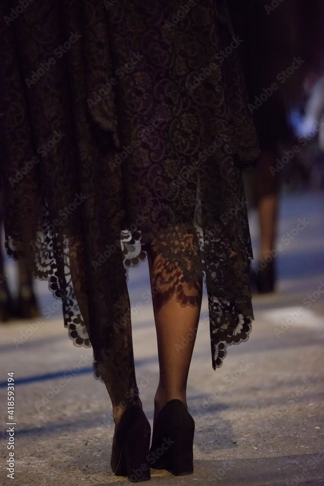 Piernas de chica con mantilla y con zapatos de tacón durante una procesión de Semana Santa Piernas de chica con mantilla y con zapatos de tacón durante una procesión de Semana Santa