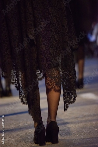 Piernas de chica con mantilla y con zapatos de tacón durante una procesión de Semana Santa