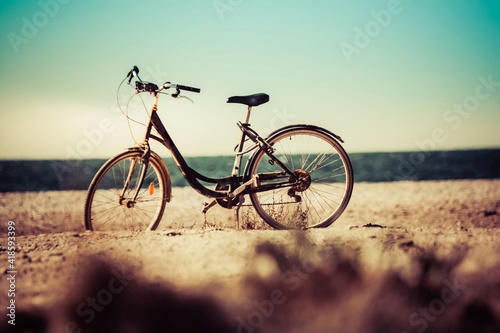 Fototapeta Naklejka Na Ścianę i Meble -  bicicleta de paseo en la playa frente al mar, vieja estilo teal y orange