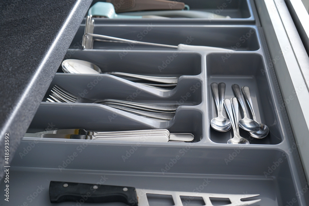 Open drawer with different utensils and cutlery in kitchen, close-up. Open drawer with different utensils and cutlery in kitchen, close-up.