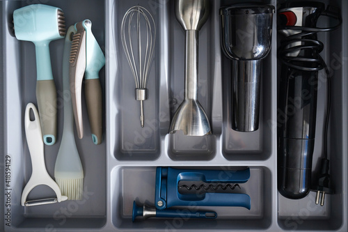 Open drawer with different utensils and cutlery in kitchen, above view.