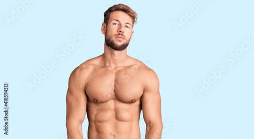 Young caucasian man standing shirtless relaxed with serious expression on face. simple and natural looking at the camera.
