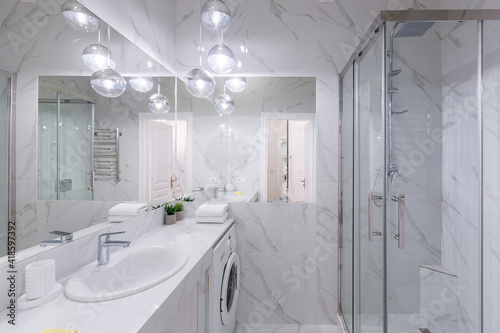 Bathroom interior with white marble tiles and modern style shower