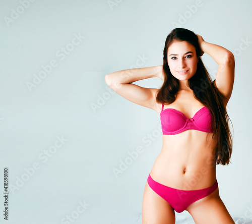 young pretty female in pink underwear in her bed smiling confident on white background, lifestyle people concept