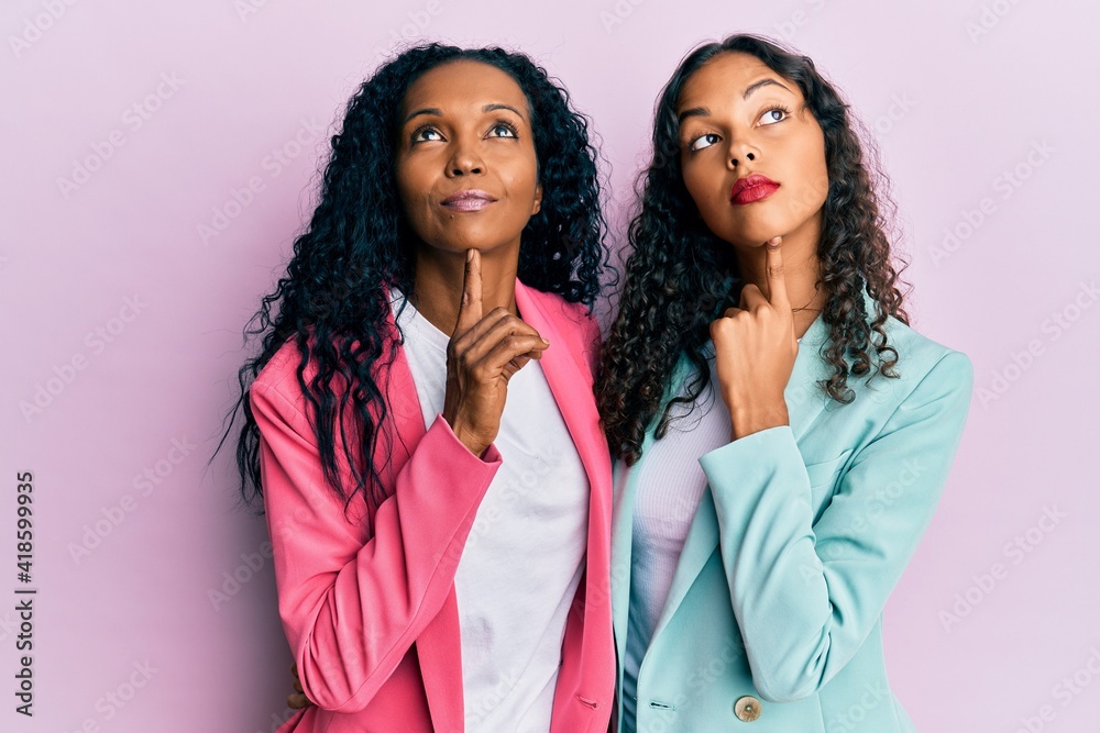 African american mother and daughter wearing business style thinking concentrated about doubt with finger on chin and looking up wondering African american mother and daughter wearing business style thinking concentrated about doubt with finger on chin and looking up wondering