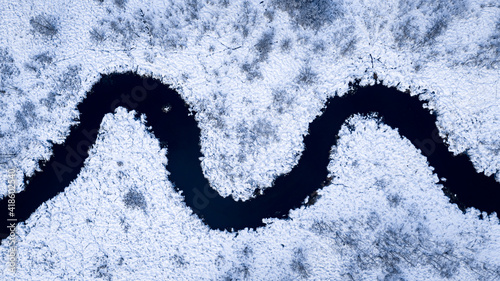 Snowy curvy river in winter. Aerial view of nature