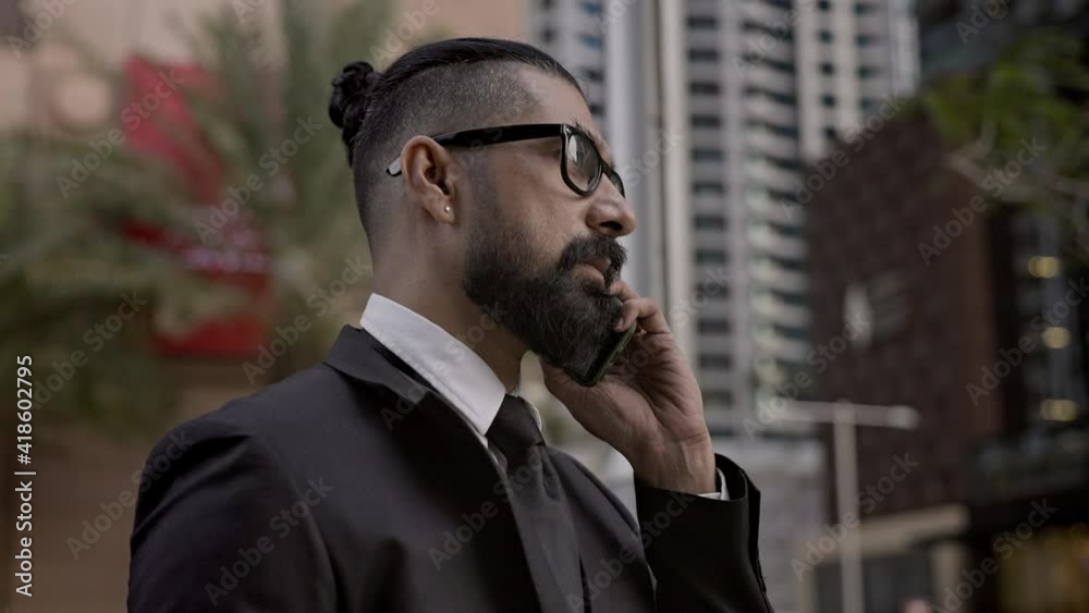 Stylish Young Man In Business Suit On Background Of The City. Tall Buildings Dubai. Man Talking On Phone. Stylish Young Man In Business Suit On Background Of The City. Tall Buildings Dubai. Man Talking On Phone.