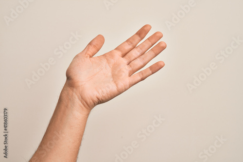 Hand of caucasian young man showing fingers over isolated white background presenting with open palm  reaching for support and help  assistance gesture