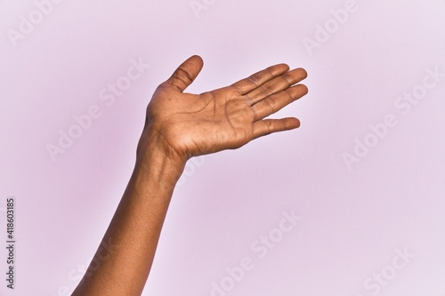 Arm and hand of black middle age woman over pink isolated background presenting with open palm, reaching for support and help, assistance gesture