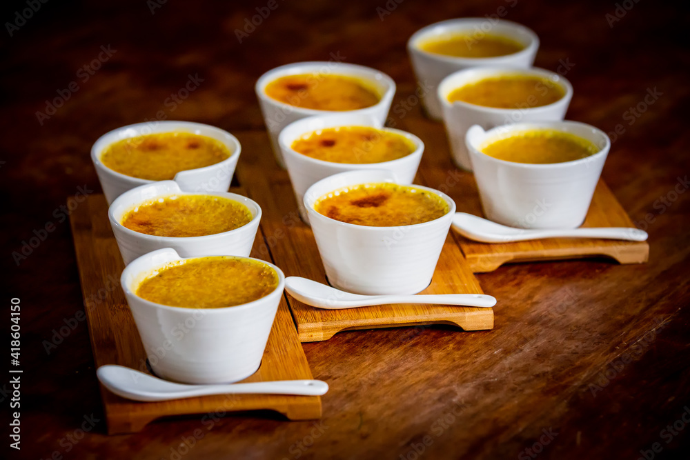 Creme brulee in characteristic ramekins, sweet dessert based on egg cream and vanilla with burnt sugar in the torch Creme brulee in characteristic ramekins, sweet dessert based on egg cream and vanilla with burnt sugar in the torch