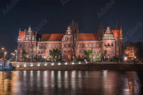 Wroclaw National Museum on the Odra River, night view from the shore.