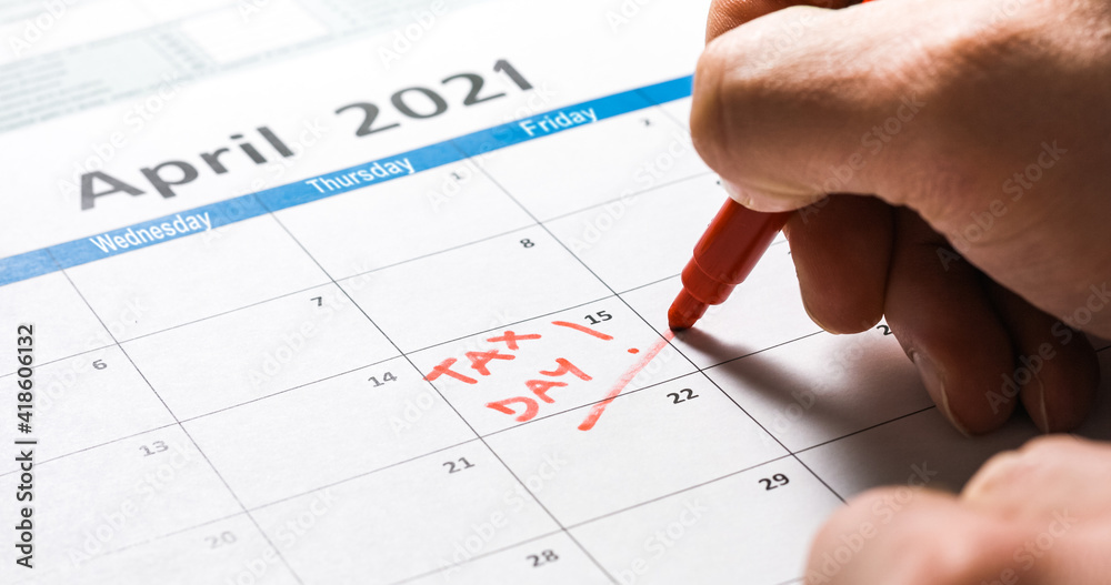 Writing tax day on 2021 April 15 calendar with red marker. Deadline for 1040 form return. Writing tax day on 2021 April 15 calendar with red marker. Deadline for 1040 form return.