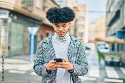 Young african american businessman with serious expression using smartphone at the city.