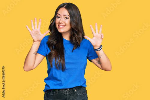 Beautiful brunette young woman wearing casual clothes showing and pointing up with fingers number nine while smiling confident and happy.