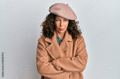 Middle age hispanic woman wearing french look with beret skeptic and nervous, disapproving expression on face with crossed arms. negative person.