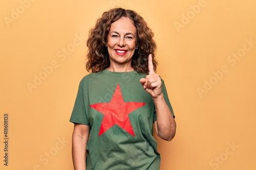 Fotografi Middle age beautiful woman wearing t-shirt with red star revolutionary symbol of