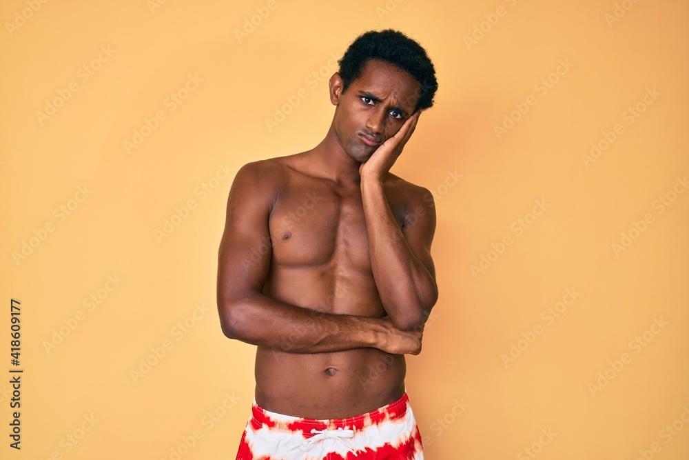 African handsome man wearing swimsuit thinking looking tired and bored with depression problems with crossed arms.