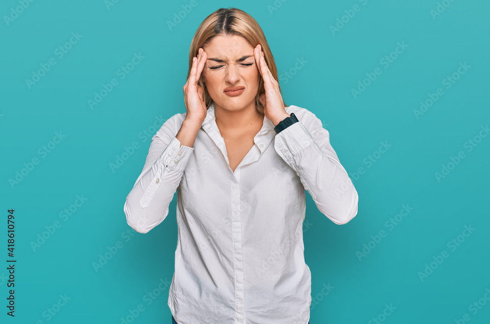 Young caucasian woman wearing casual clothes with hand on head, headache because stress. suffering migraine. Young caucasian woman wearing casual clothes with hand on head, headache because stress. suffering migraine.