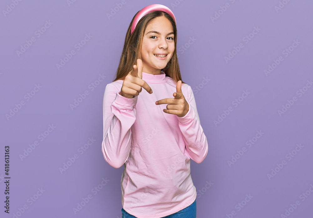 Beautiful brunette little girl wearing casual turtleneck sweater pointing fingers to camera with happy and funny face. good energy and vibes. Beautiful brunette little girl wearing casual turtleneck sweater pointing fingers to camera with happy and funny face. good energy and vibes.