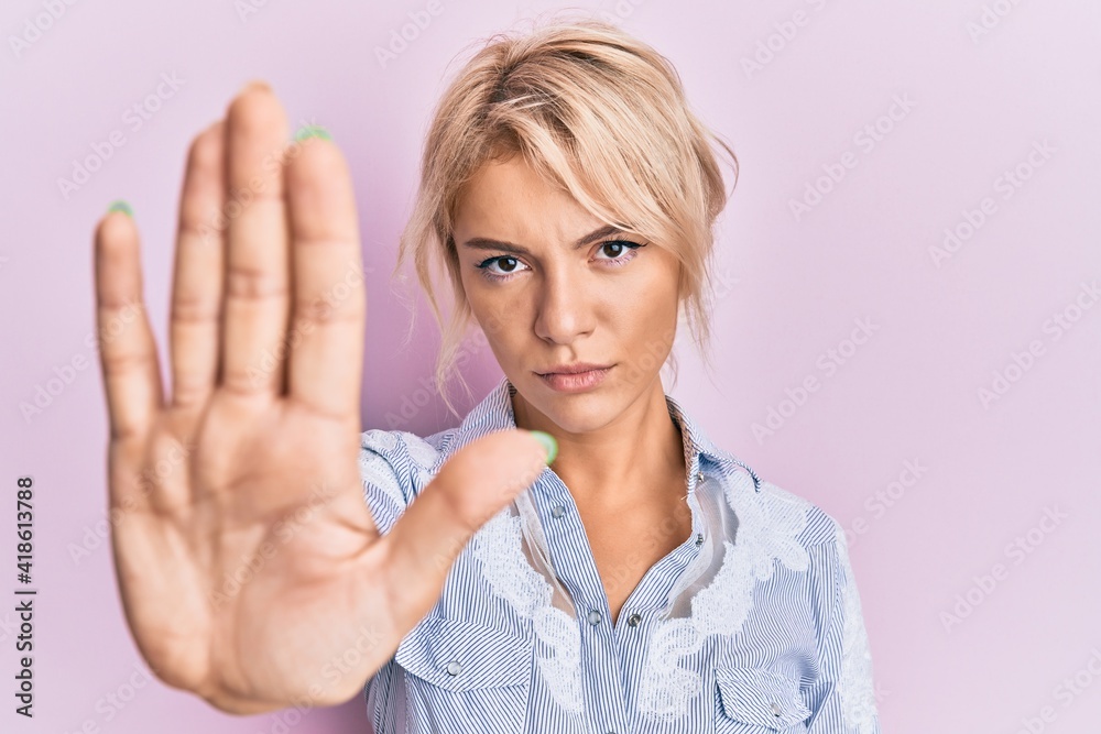 Young blonde girl wearing casual clothes doing stop sing with palm of the hand. warning expression with negative and serious gesture on the face. Young blonde girl wearing casual clothes doing stop sing with palm of the hand. warning expression with negative and serious gesture on the face.