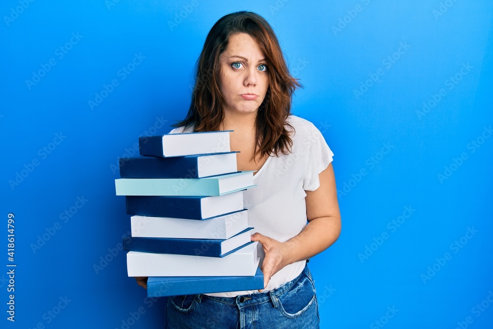 Young caucasian woman holding a pile of books depressed and worry for distress, crying angry and afraid. sad expression. Young caucasian woman holding a pile of books depressed and worry for distress, crying angry and afraid. sad expression.