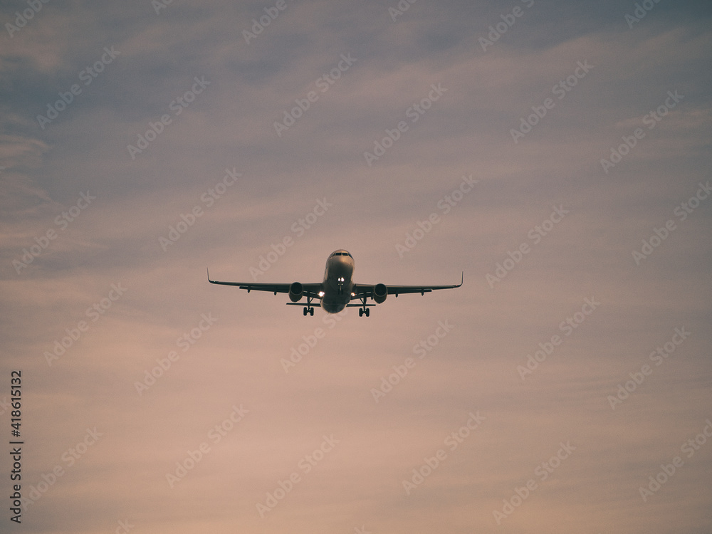 airplane flying at sunset