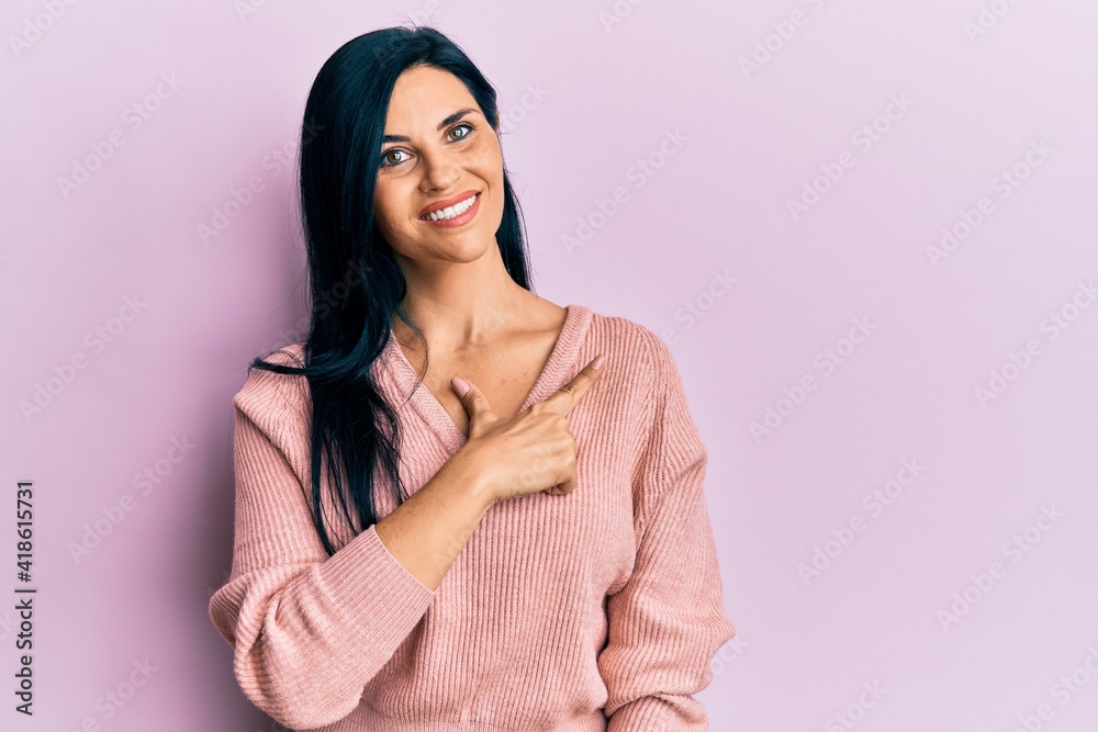 Young caucasian woman wearing casual clothes cheerful with a smile on face pointing with hand and finger up to the side with happy and natural expression Young caucasian woman wearing casual clothes cheerful with a smile on face pointing with hand and finger up to the side with happy and natural expression
