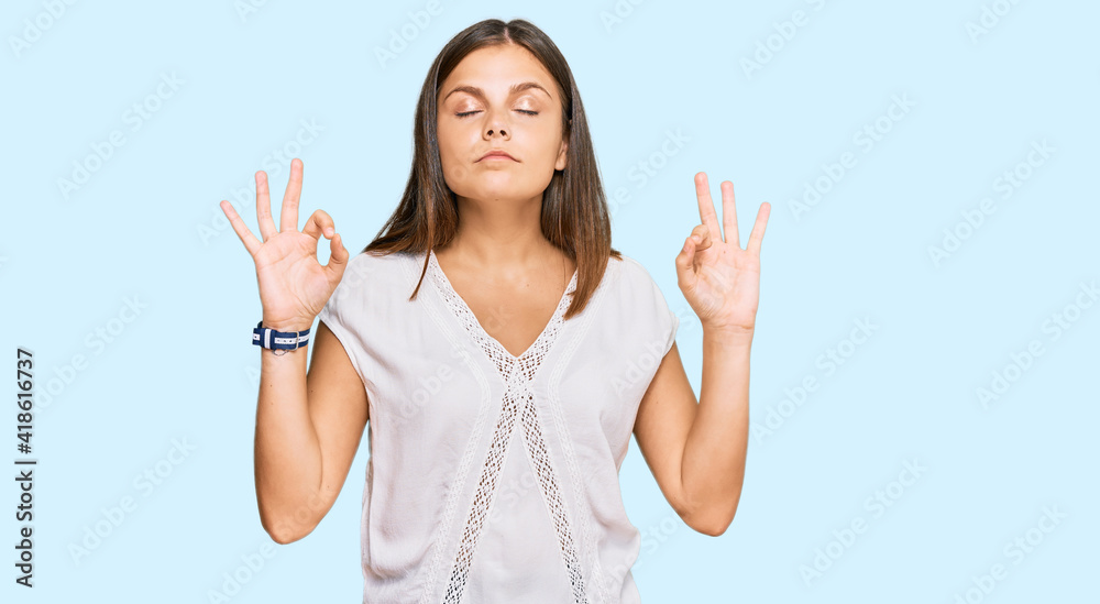 Young caucasian woman wearing casual clothes relax and smiling with eyes closed doing meditation gesture with fingers. yoga concept. Young caucasian woman wearing casual clothes relax and smiling with eyes closed doing meditation gesture with fingers. yoga concept.