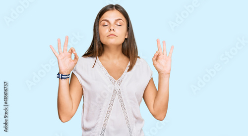 Young caucasian woman wearing casual clothes relax and smiling with eyes closed doing meditation gesture with fingers. yoga concept.