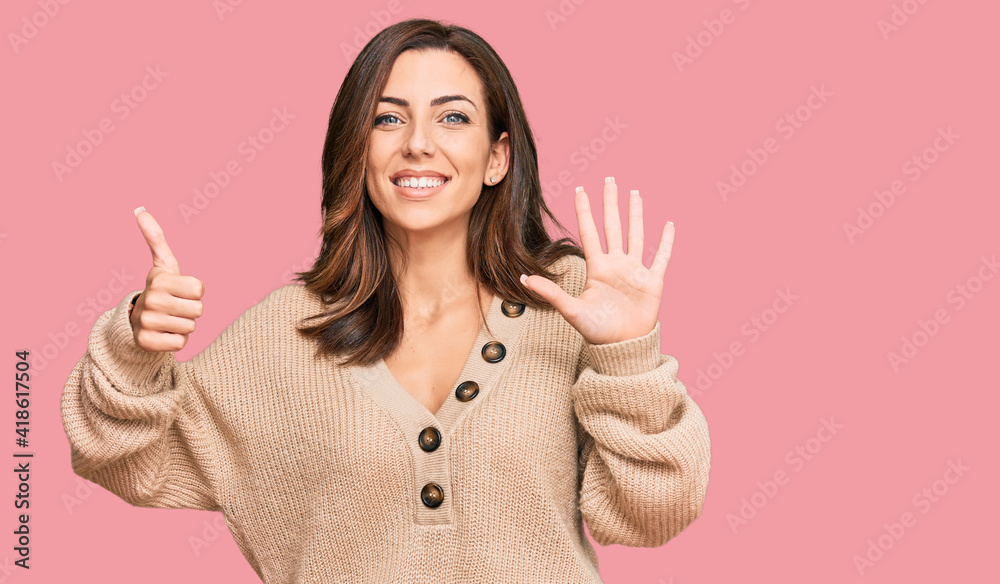 Young brunette woman wearing casual winter sweater showing and pointing up with fingers number six while smiling confident and happy. Young brunette woman wearing casual winter sweater showing and pointing up with fingers number six while smiling confident and happy.