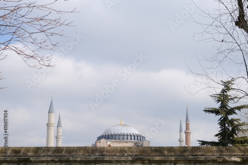 Turkey istanbul 03.03.2021. Facade and outside of Hagia sophia mosque now,before museum and ancient church from sultanahmet square with tourist palm trees during blue overcast sky background. 