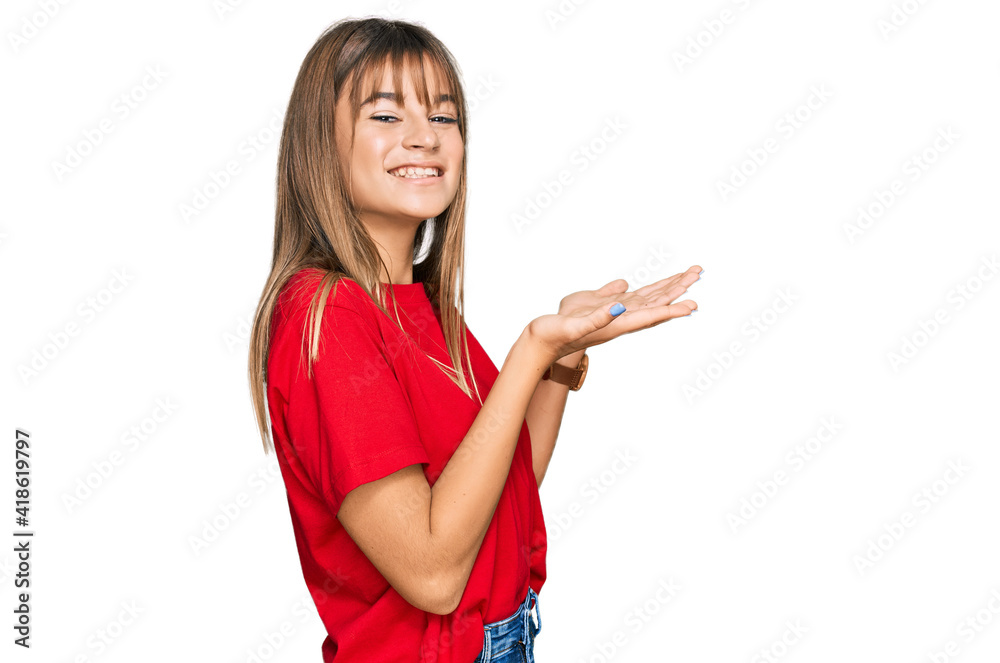 Teenager caucasian girl wearing casual red t shirt pointing aside with hands open palms showing copy space, presenting advertisement smiling excited happy Teenager caucasian girl wearing casual red t shirt pointing aside with hands open palms showing copy space, presenting advertisement smiling excited happy