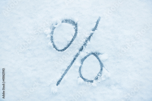Percent sign written on a snow. Abstract symbol.