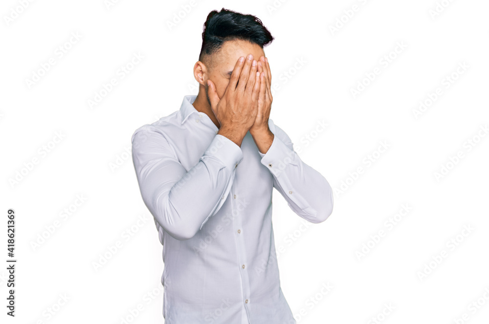Young arab man wearing casual clothes with sad expression covering face with hands while crying. depression concept. Young arab man wearing casual clothes with sad expression covering face with hands while crying. depression concept.
