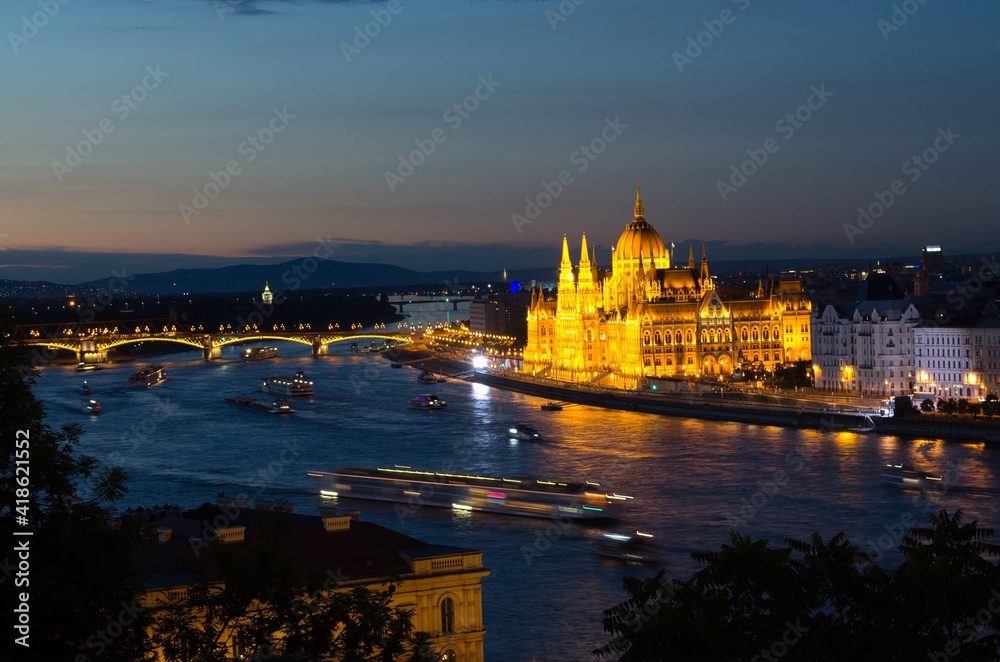 Night view of illuminated beautiful Parliament building across river Danube in Budapest, Hungary