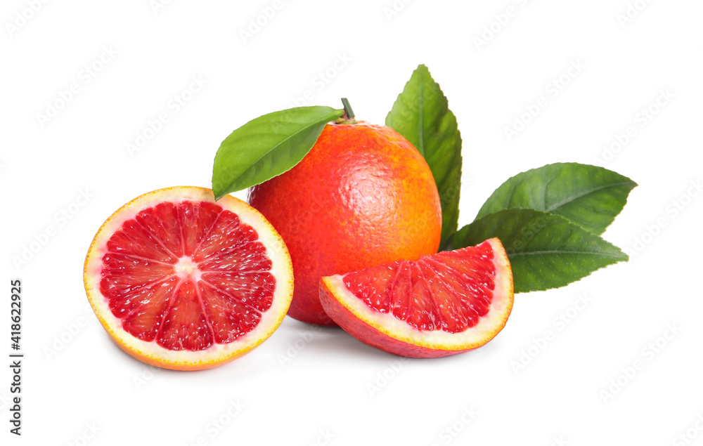 Whole and cut red oranges with green leaves on white background Whole and cut red oranges with green leaves on white background