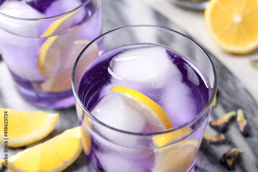 Organic blue Anchan with lemon and ice cubes on table, closeup. Herbal tea Organic blue Anchan with lemon and ice cubes on table, closeup. Herbal tea